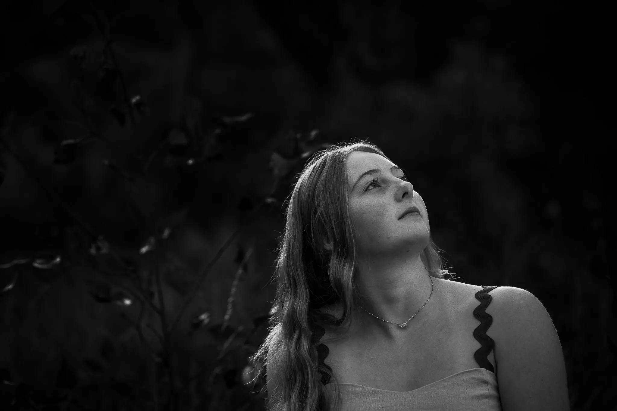 Black and white portrait of a young woman looking upward